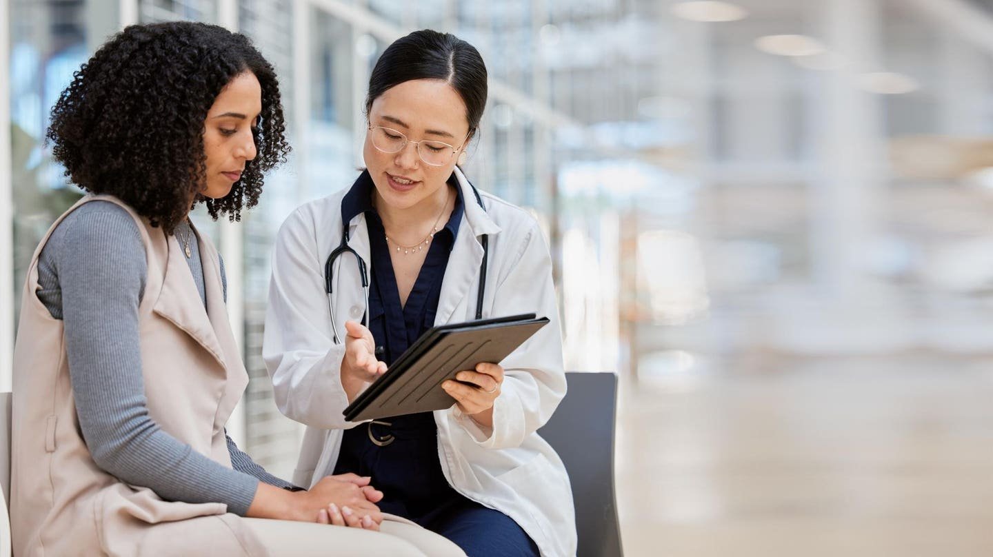A doctor discussing aesthetic treatment options with a patient before travel
