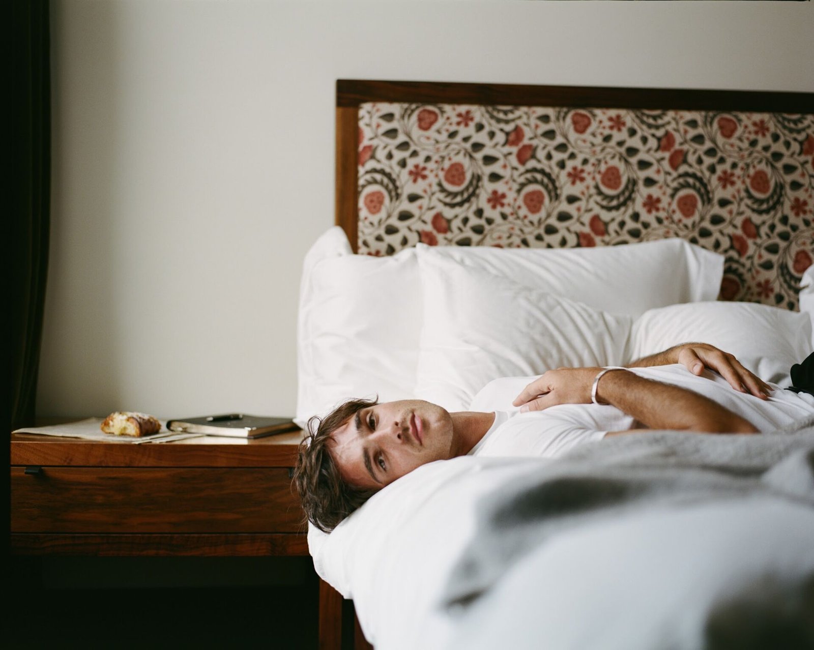 Jacob Elordi lying in a hotel bed
