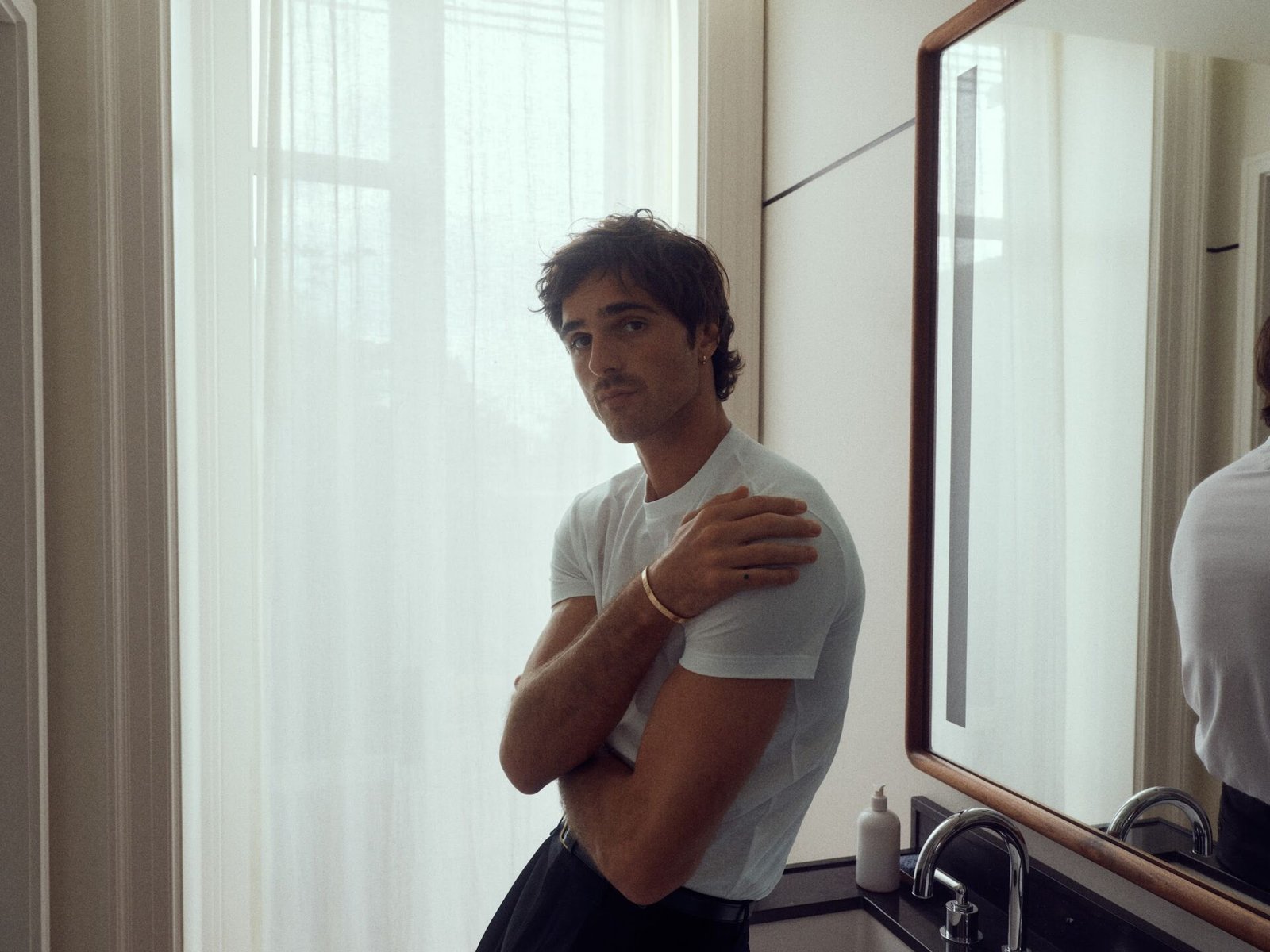 Jacob Elordi in front of a mirror wearing the LOVE bracelet