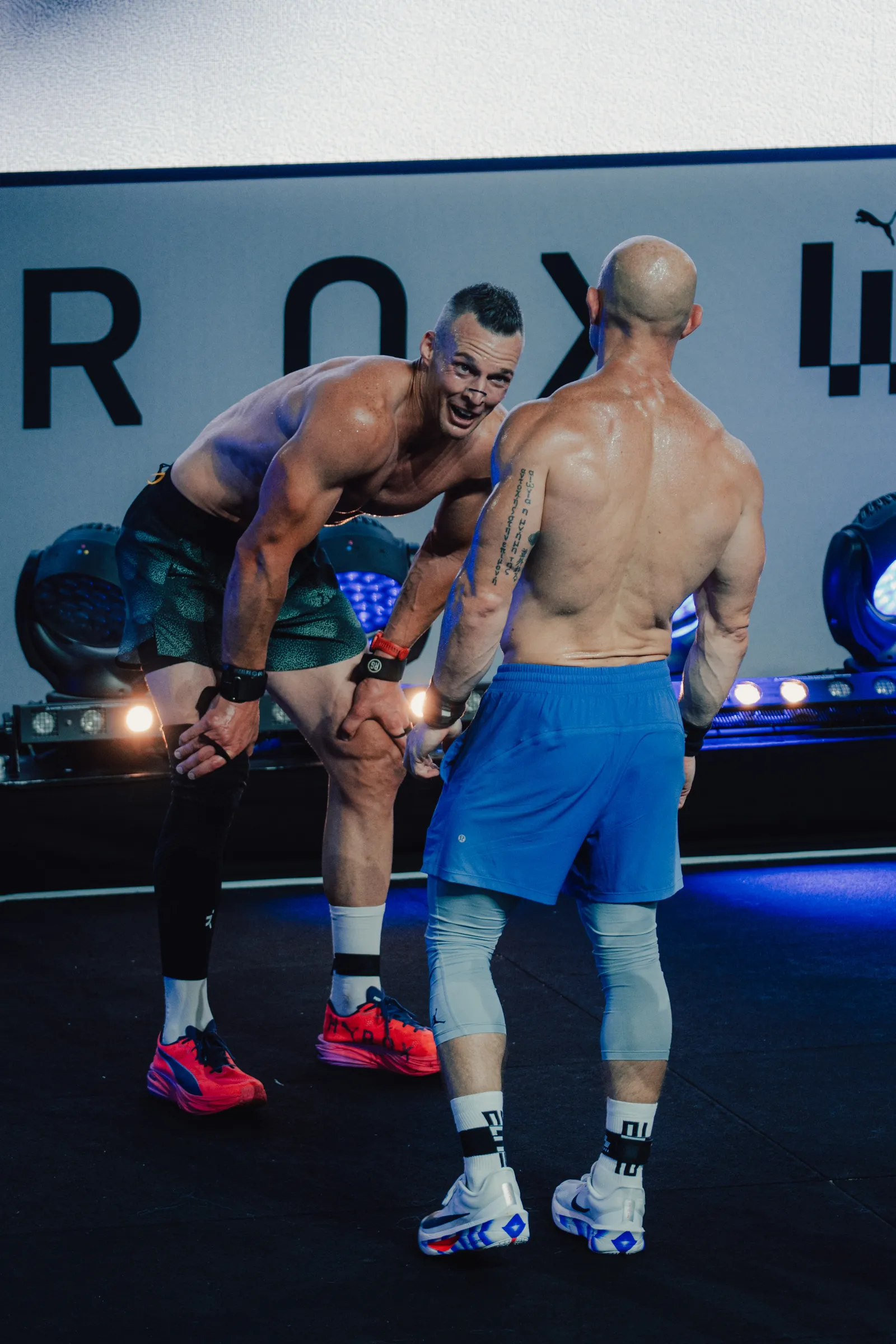 An athlete crosses the finish line alongside another competitor at the HYROX World Championships