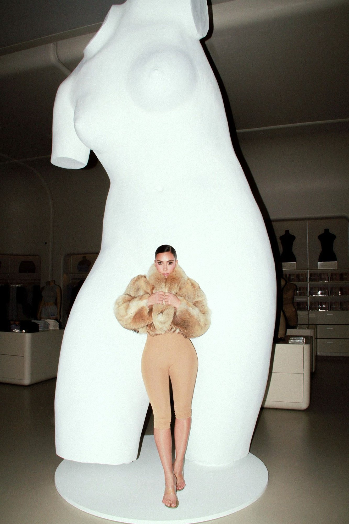 Kim Kardashian inside a Skims store beside a Vanessa Beecroft sculpture