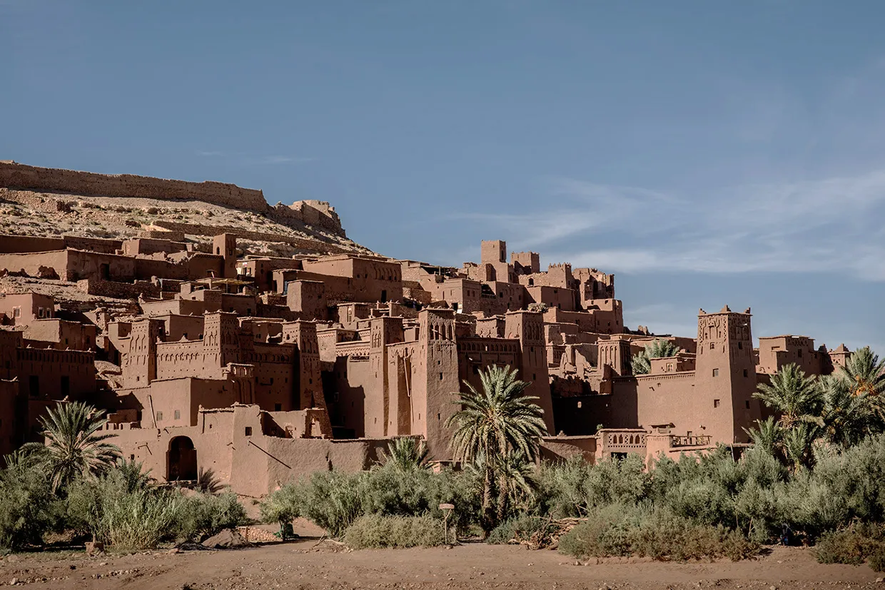 Rammed-earth buildings at Ait Benhaddou with palms at the foot of the hill