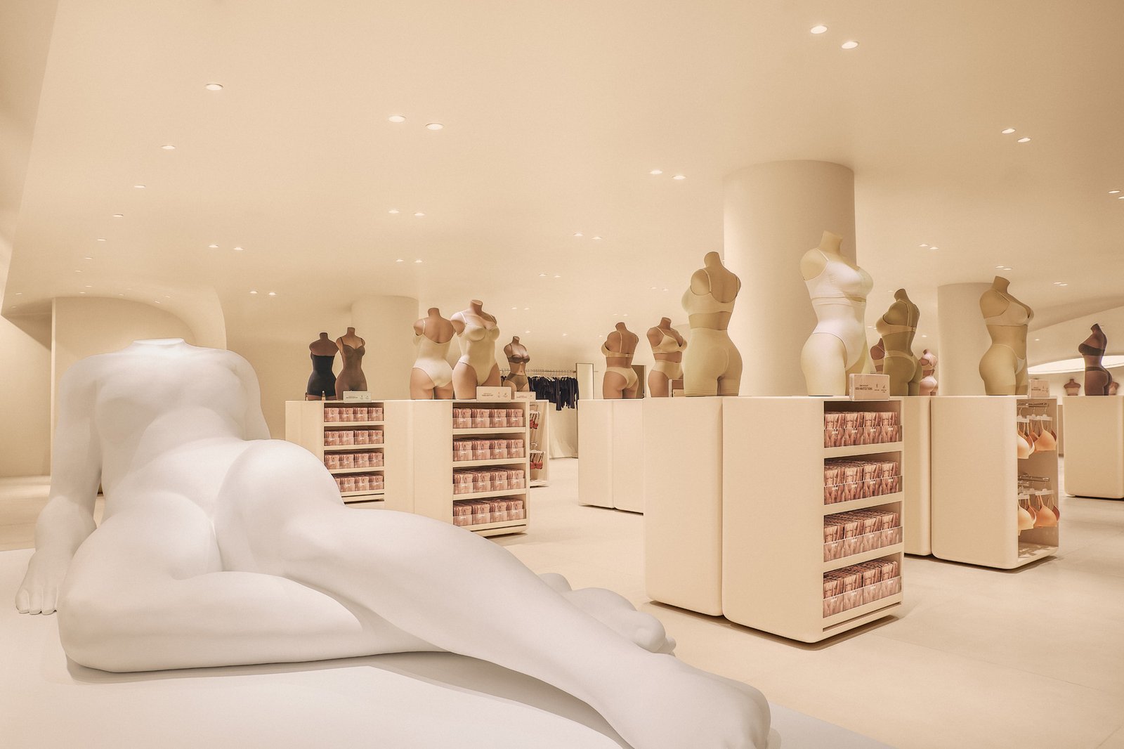Detail of a curved wall and greige finish inside the Skims store
